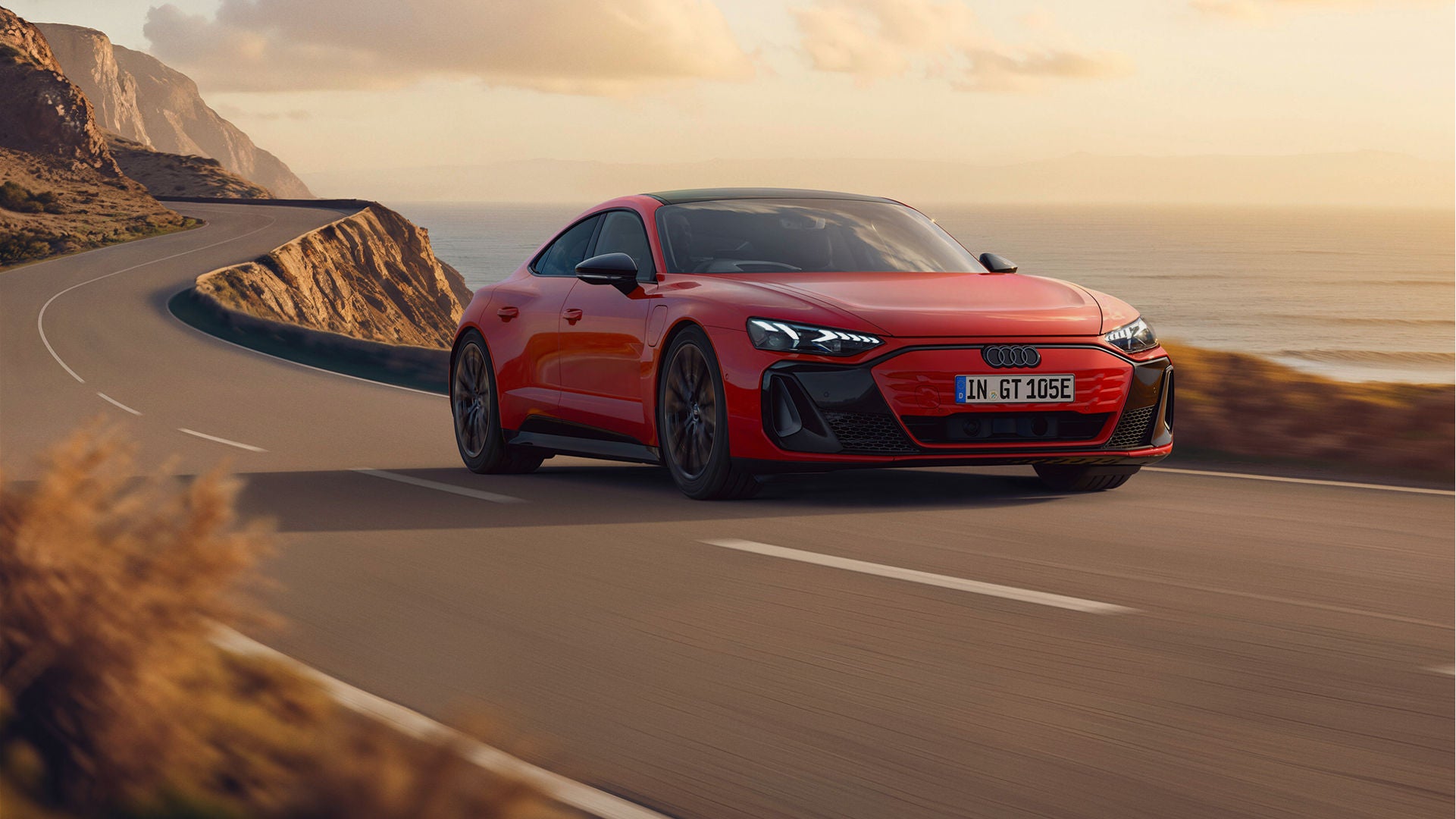 Red Audi e-tron GT quattro driving on a coastal road