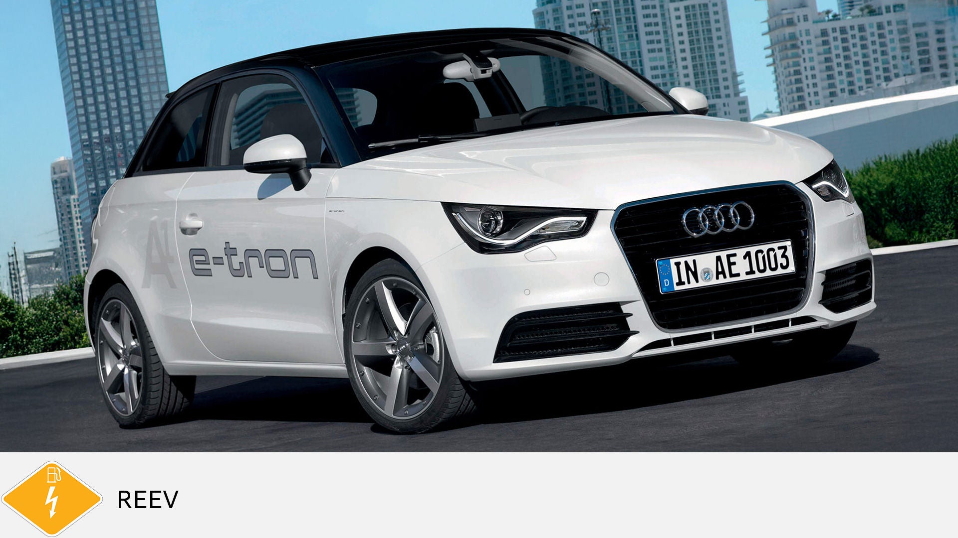 Weißer Audi A1 e-tron mit schwarzem Dach steht vor Hochhäusern, unten gelbes Symbol für REEV mit Blitz und Ladekabel.