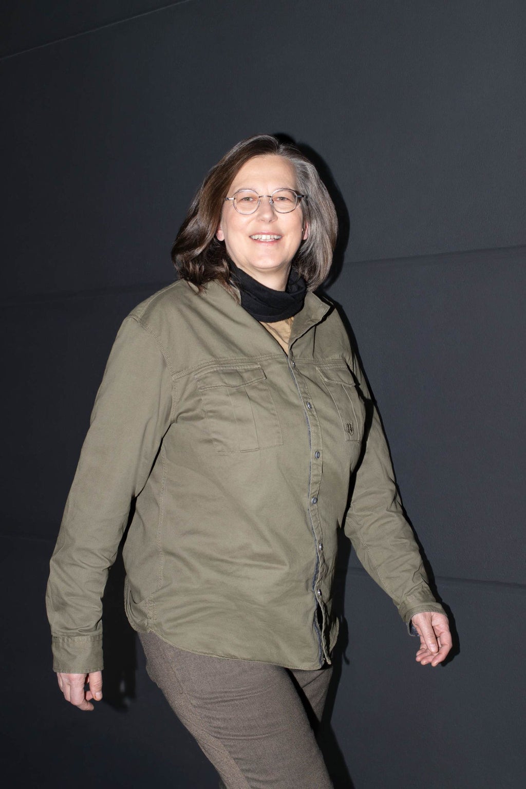 Portretfoto van Annegret Matthai van Advanced Development of Vehicle Body Structure bij AUDI AG. Zij loopt voor een donkere achtergrond met haar bovenlichaam richting de camera gedraaid.