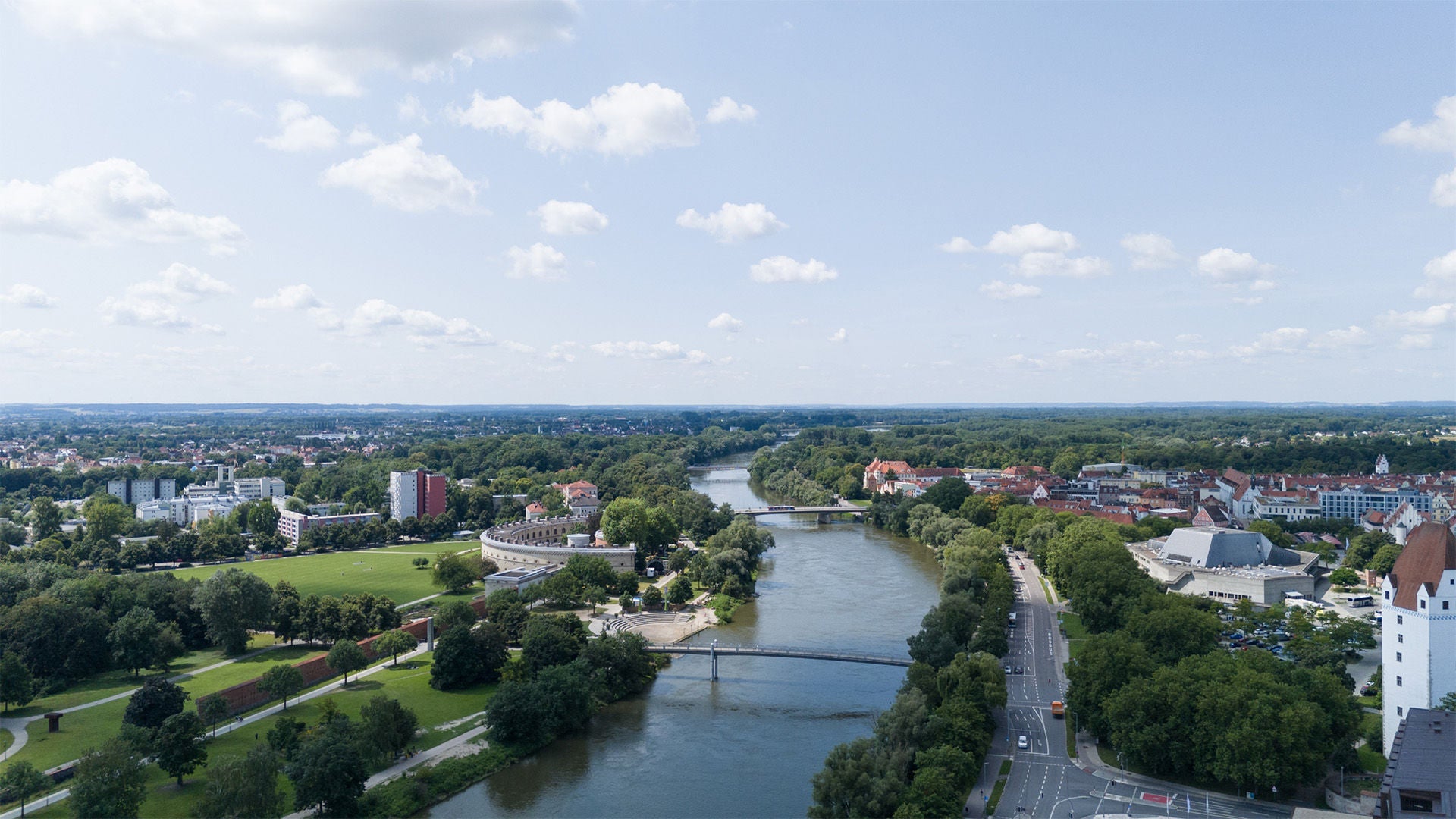 Panoramic view of Ingolstadt with river, bridges, green areas and historic old town.