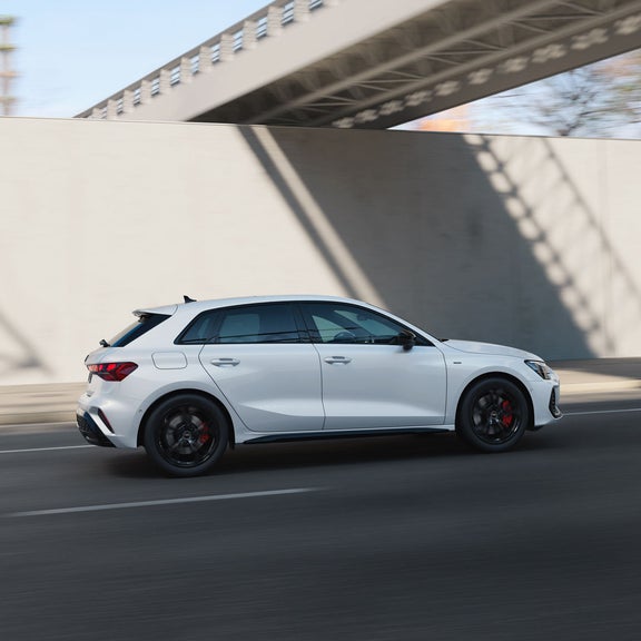 A close-up shot from the side shows an Audi A3 Sportback e-hybrid driving across a bridge.
