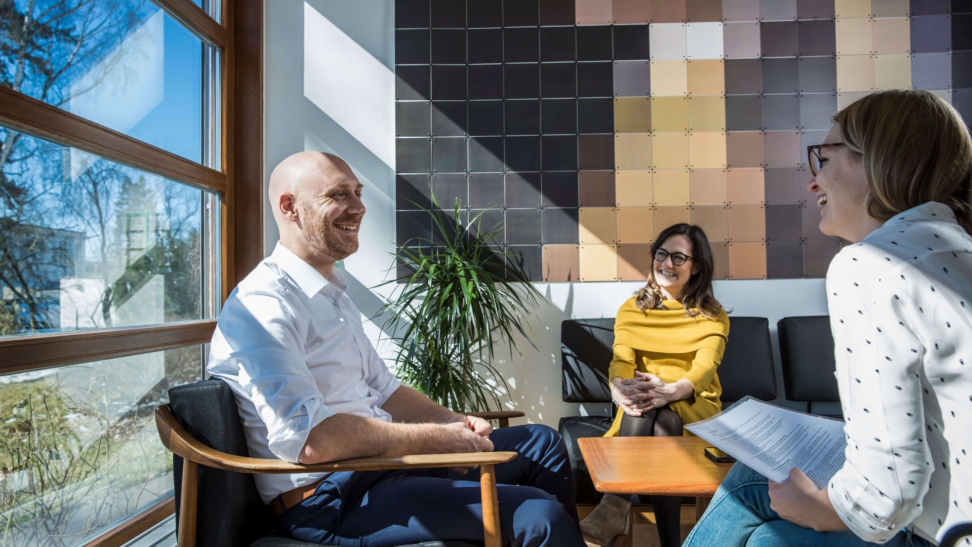 Drei Personen sitzen zusammen und unterhalten sich