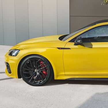 Audi RS5 Coupé in yellow from the side