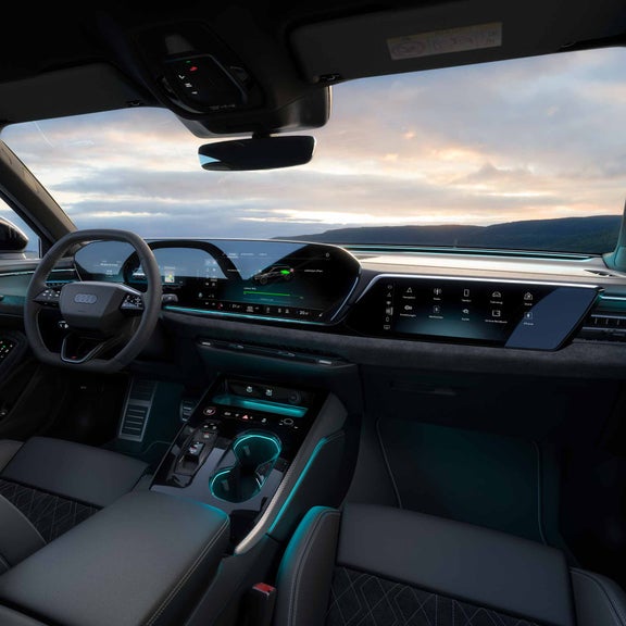 Der Innenraum eines Audi A5 Avant e-hybrid mit den Displays. Durch die Frontscheibe sind Hügel zu erkennen.