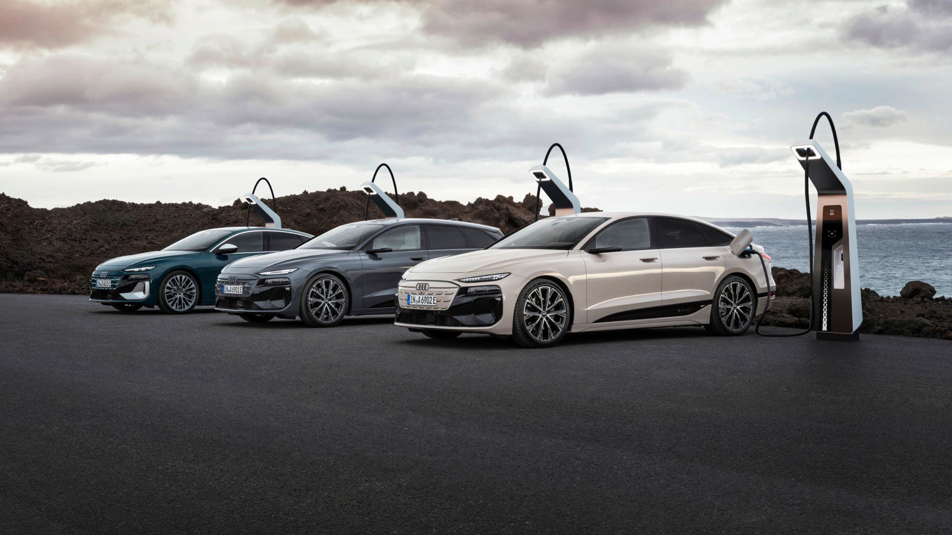 Varianten des Audi A6 e-tron stehen an Ladesäulen