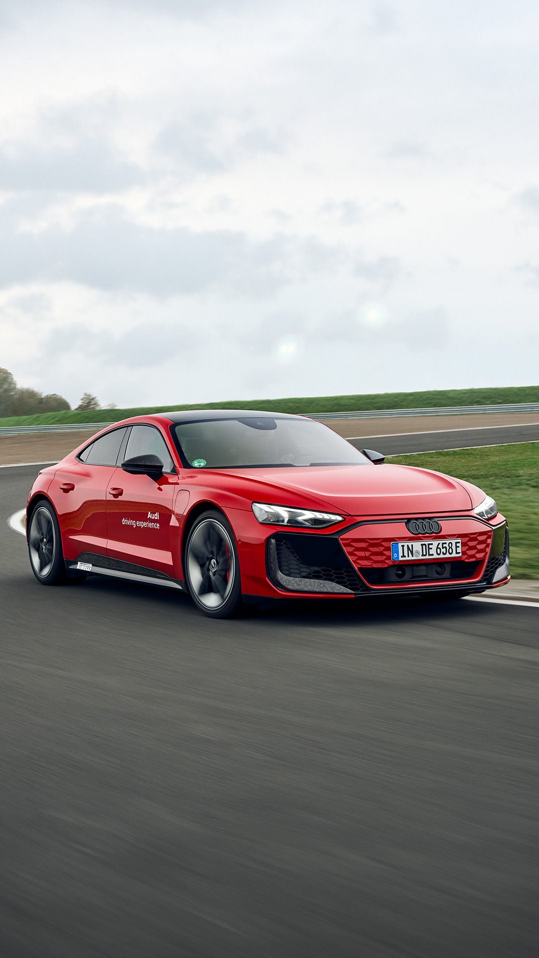 Two red Audi RS e-tron GTs on the racetrack in a bend.