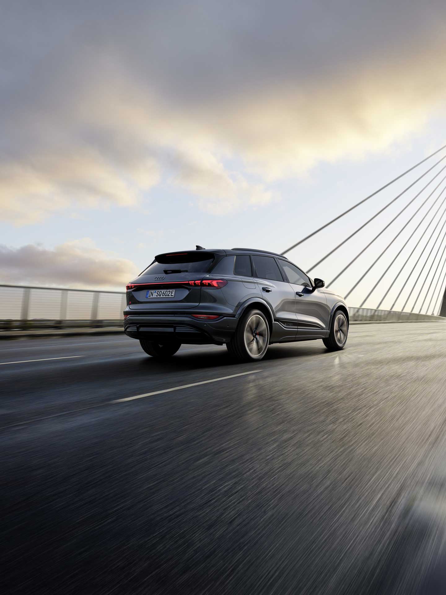 Der SQ6 SUV e-tron aus schräger Heckperspektive fährt über eine Brücke.