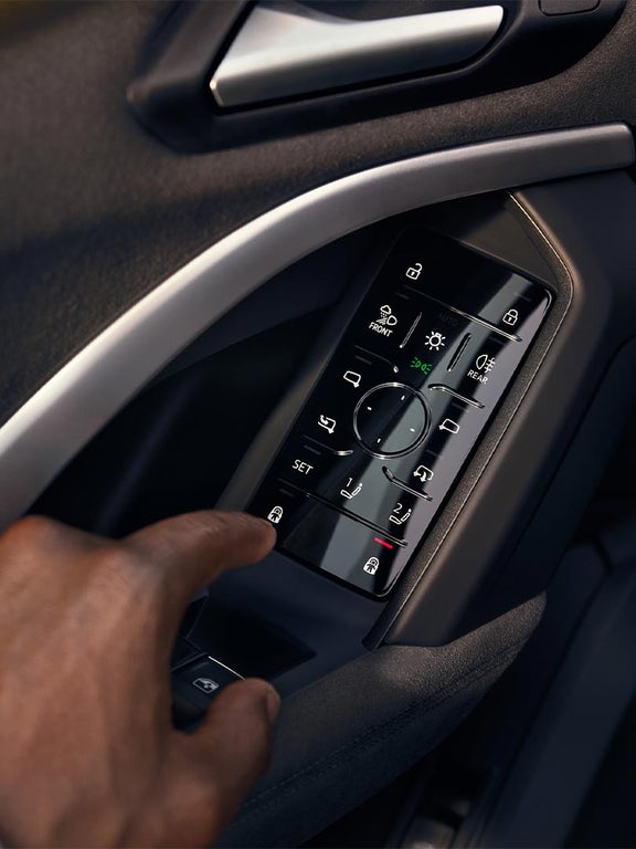 Nahaufnahme einer Hand, die ein Bedienfeld an der Fahrertür des Audi Q5 Sportback betätigt.