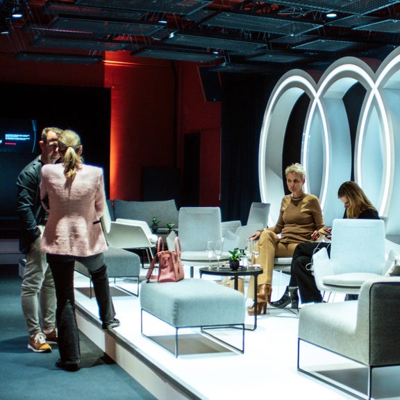 Speaker_innen auf der Bühne vor einem Audi Logo