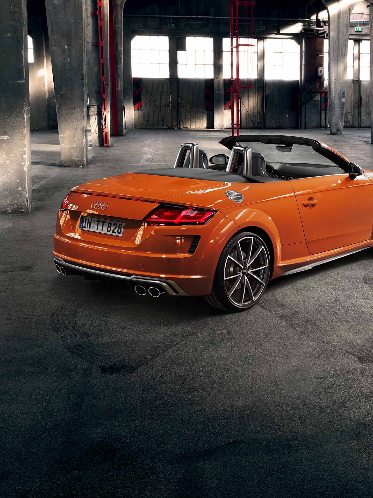 Orange Audi TT Roadster moving fast in an underground car park.