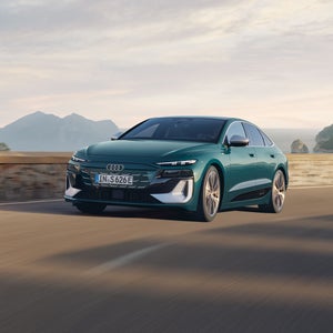Der S6 Sportback e-tron im schrägen Frontprofil, während er eine Küstenstraße entlangfährt.