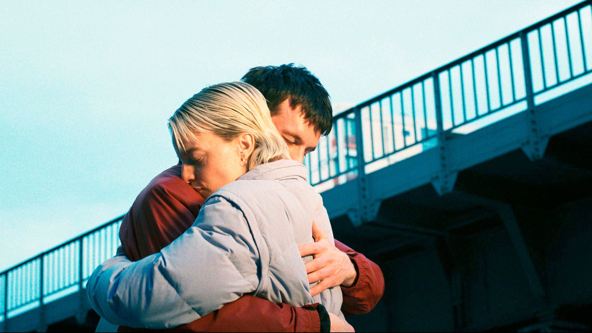 Tanja und Jerome umarmen sich unter einer Brücke.
