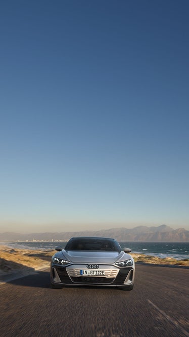 Audi e-tron GT framifrån med snötäckande berg i bakgrunden.