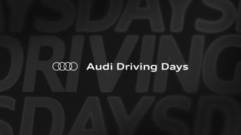 Audi Logo und Schriftzug „Audi Driving Days“ auf dunklem Hintergrund.