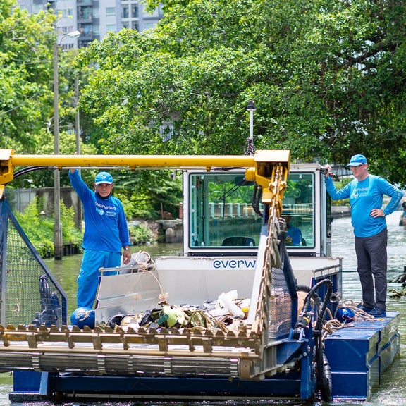Zwei Menschen auf einem Müllsammelboot