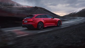 The RS 5 Avant in a slanted profile from behind on a dark background.