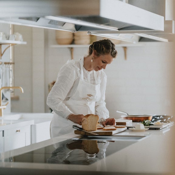 Theresa Baumgärtner steht in einer Küche und schmiert Brote.