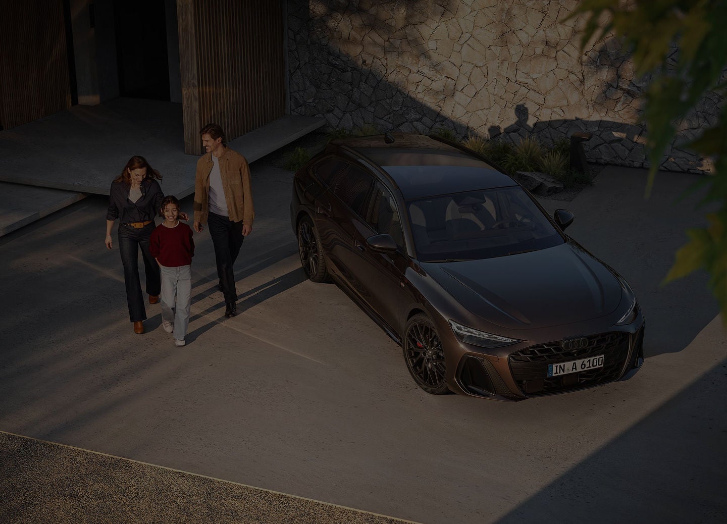 A young couple walking away from a parked Audi Q4 e-tron car