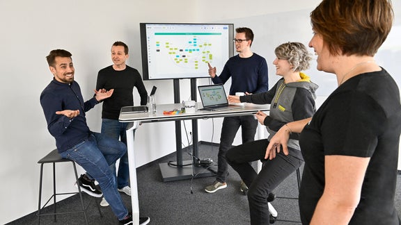 Markus, Product Manager SCD, looks at a laptop with a colleague