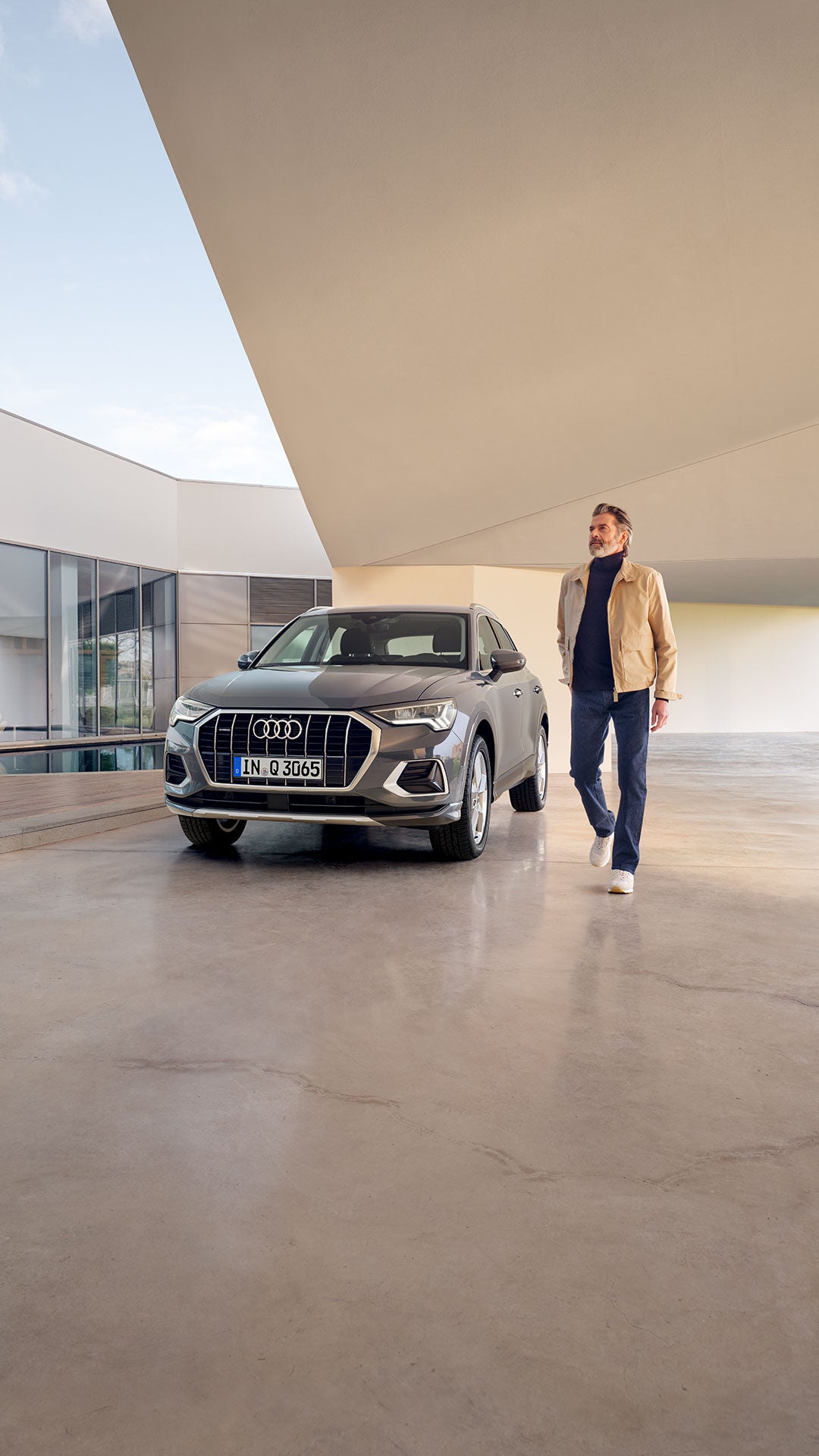 Mann läuft weg vom Audi A3 Gebrauchtwagen in einer modernen Halle.