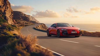 Red Audi e-tron GT quattro cruising on a curvy coastal road