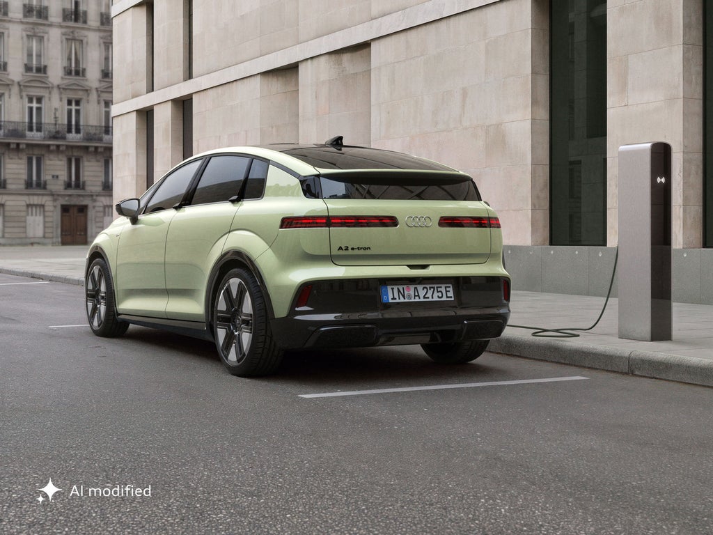 Un Audi A2 e-tron cargando en la calle.