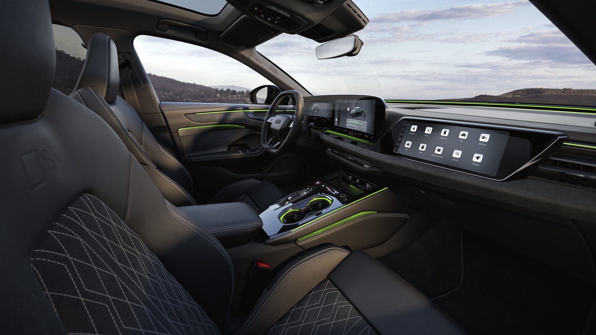 The cockpit of the A6 Saloon e-hybrid from the passenger's perspective. The focus is on the steering wheel, the panoramic displays, and the green ambient lighting.