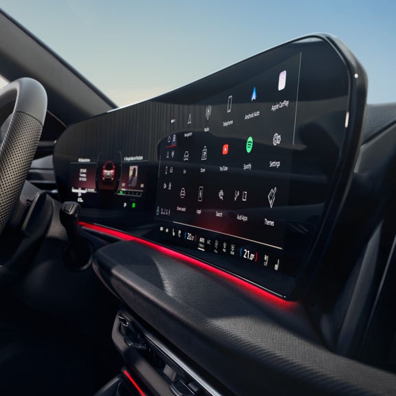 Car dashboard view with steering wheel, speedometer, and a heads-up display projecting speed limit and speed.