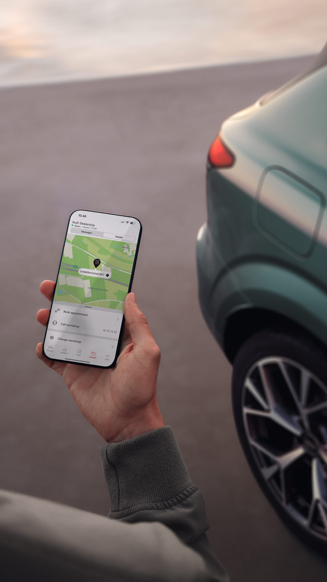 En mand med mitAudi appen på sin telefon