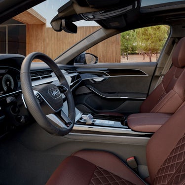 Car interior with leather seats, steering wheel, and modern dashboard.