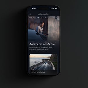 Nahaufnahme eines Smartphone-Displays. Der Nutzer befindet sich im Audi Functions Store eines S6 Sportback e-tron.