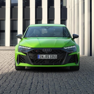 Frontansicht eines grünen Audi RS 3 Sportback mit LED-Scheinwerfern und schwarzem Wabengrill.