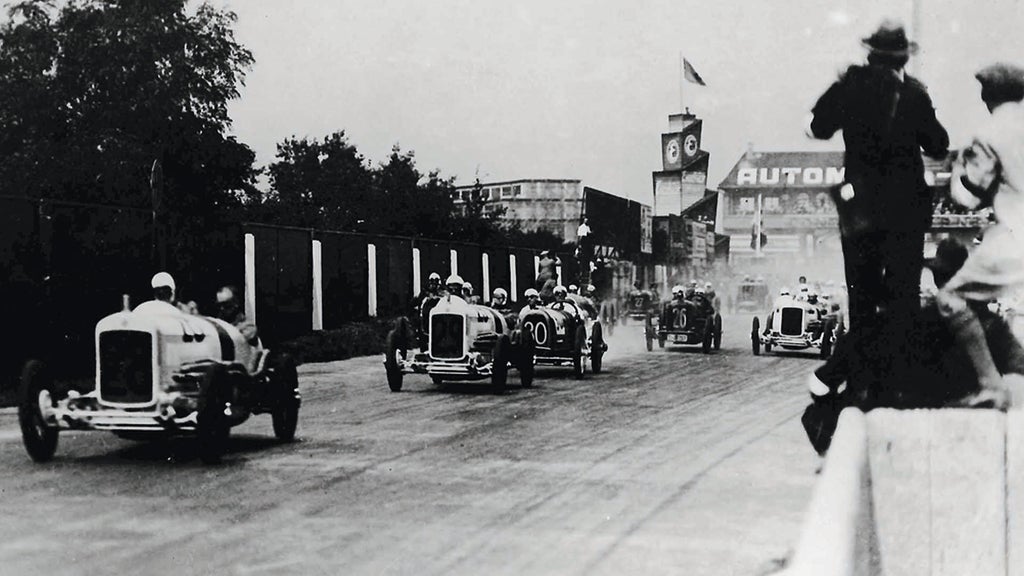 A picture showing two NSU race cars in front of more race cars on track.