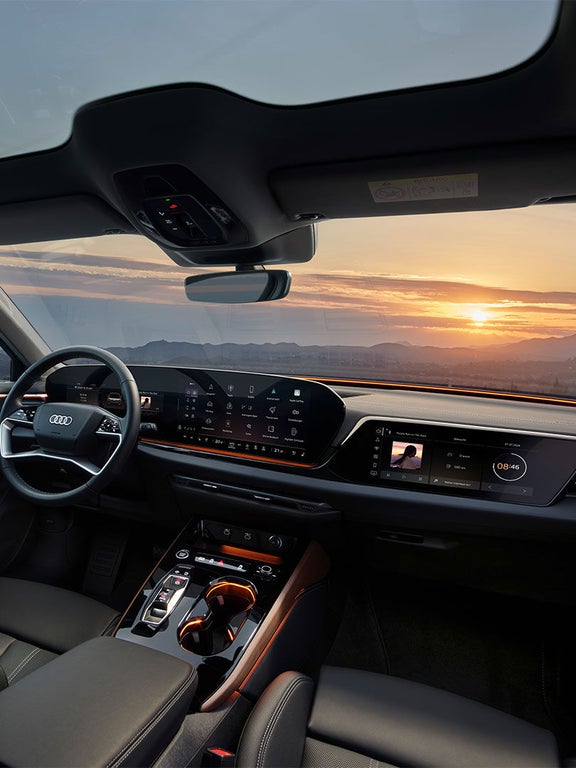 Weitwinkelaufnahme des digitalen Cockpits im Audi A5 Avant mit Blick auf Sonnenuntergang und komplette Armatur.