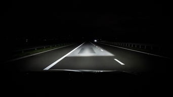 Digital Matrix LED headlights on the Audi Q3 with activated Lane and Orientation Light shines on a street at night