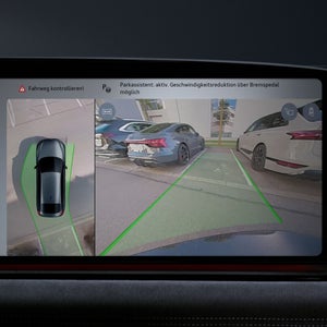 Nahaufnahme eines Displays im Fahrzeuginnenraum. Abgebildet ist eine Parksituation aus zwei Perspektiven: von oben auf das Fahrzeug und von der Heckkamera.