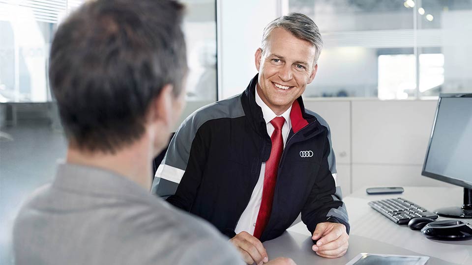 アウディのファイナンスプランについて案内するスタッフ