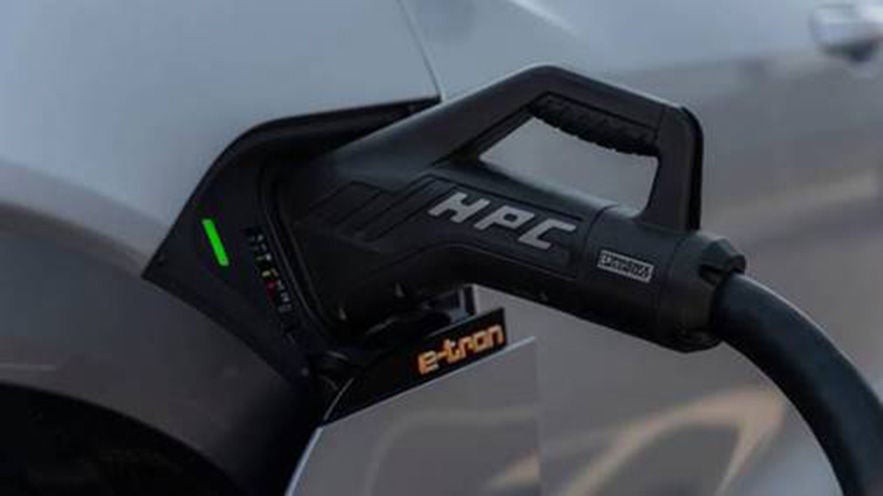 Ladekabel mit HPC-Aufschrift ist an einem Audi e-tron Elektrofahrzeug angeschlossen, grüne LED zeigt aktiven Ladevorgang an.