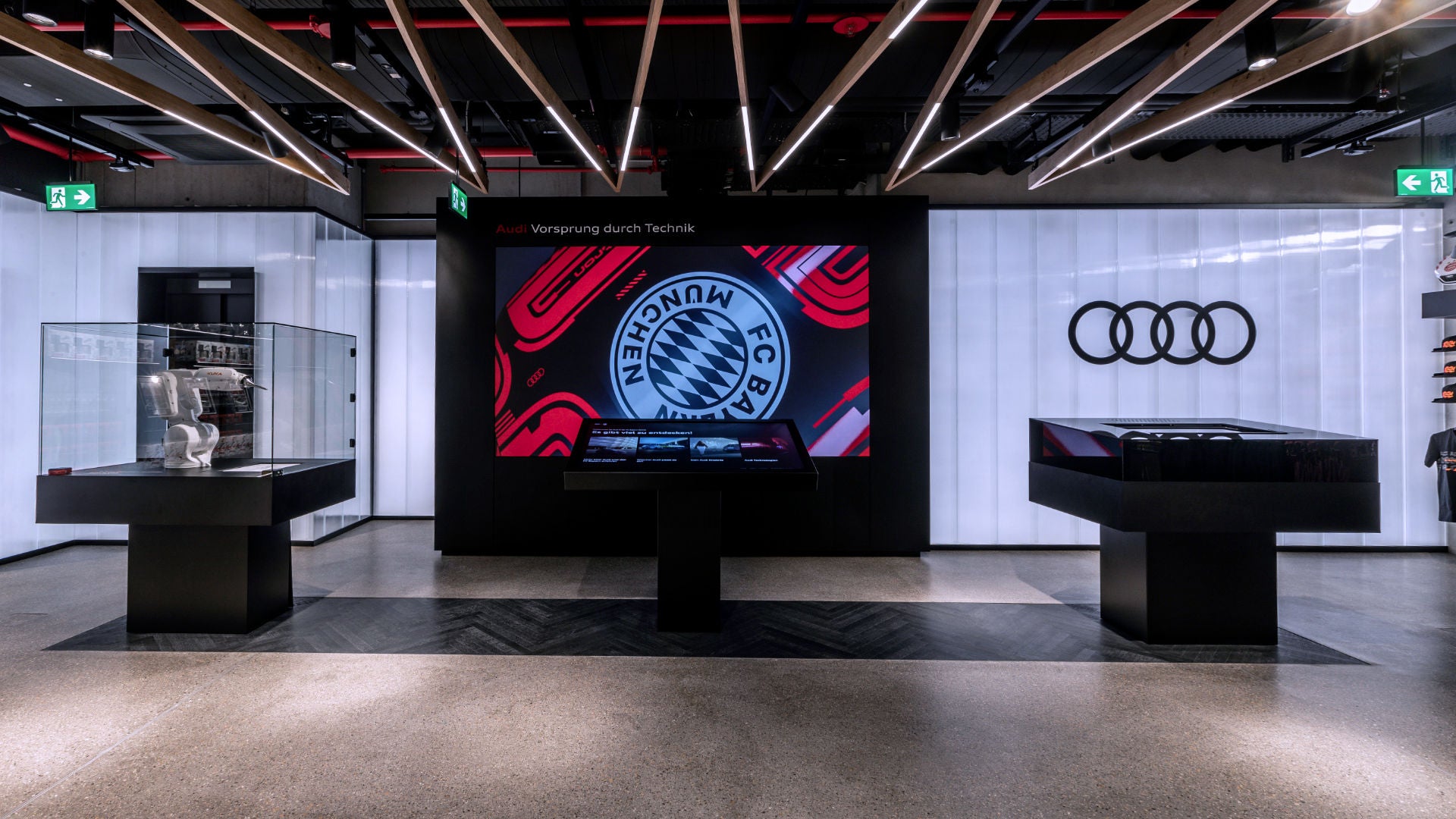 Schaukästen und ein Monitor mit dem FC Bayern Logo in der FC Bayern Erlebniswelt