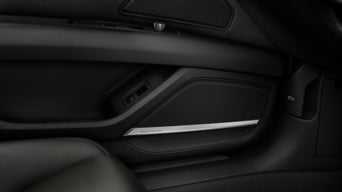 Interior view of a car door with a "Bang & Olufsen" speaker system.
