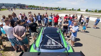 A group of people stand around an Audi model