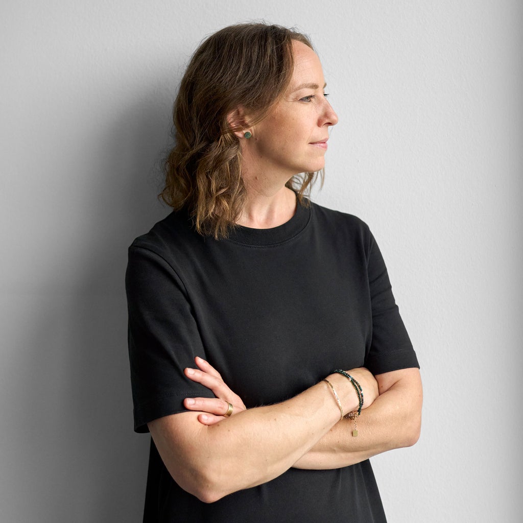 Melanie Limmer hat ihre Hände in den Hosentaschen und ist an eine Wand gelehnt