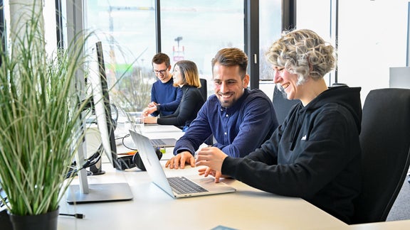 Markus, Product Manager SCD, looks at a laptop with a colleague