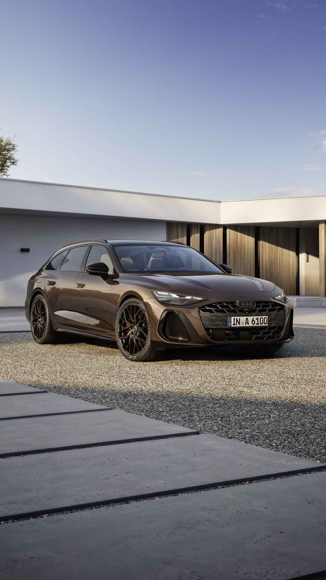 A6 Avant står i en vinkel på en grusbelagd yta framför ett modernt hus. Bilens strålkastare visar en ljussignatur.