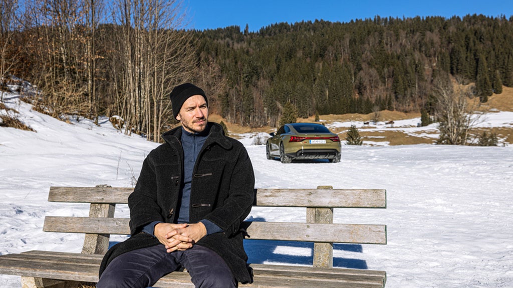 Pause für den RS e-tron GT. Felix Neureuther nimmt sich einen Moment, um die Natur zu genießen. Als Audi Markenbotschafter und als Vater setzt er sich für Nachhaltigkeit ein.