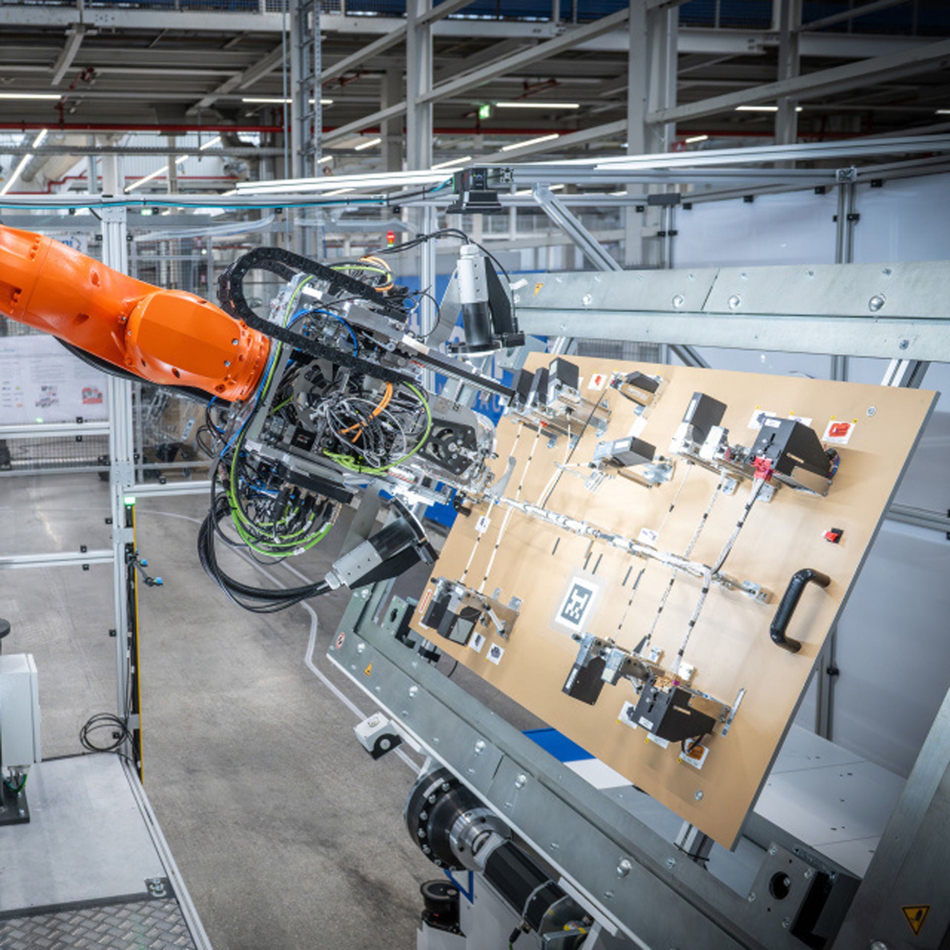 Ein Roboterarm beim automatisierten Taping eines Leitungssatzes in einer Fertigungshalle im Werk Ingolstadt.