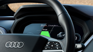 Black Audi Q4 e-tron steering wheel with silver logo, centre console display showing green range indicator.