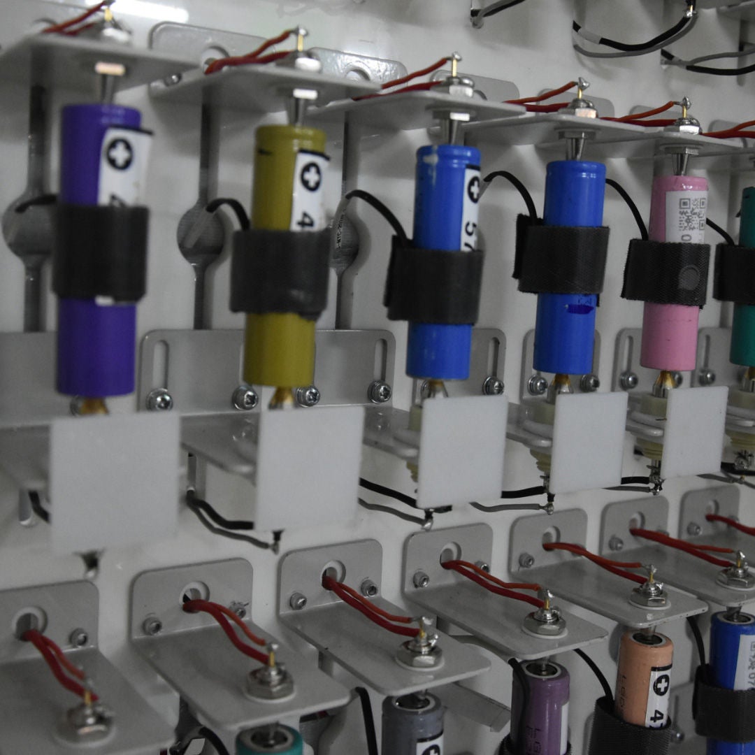 An e-rickshaw drives along a cobbled road lined with trees.