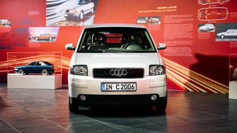 Ein älteres Audi Modell steht zur Präsentation vor einer Werbetafel