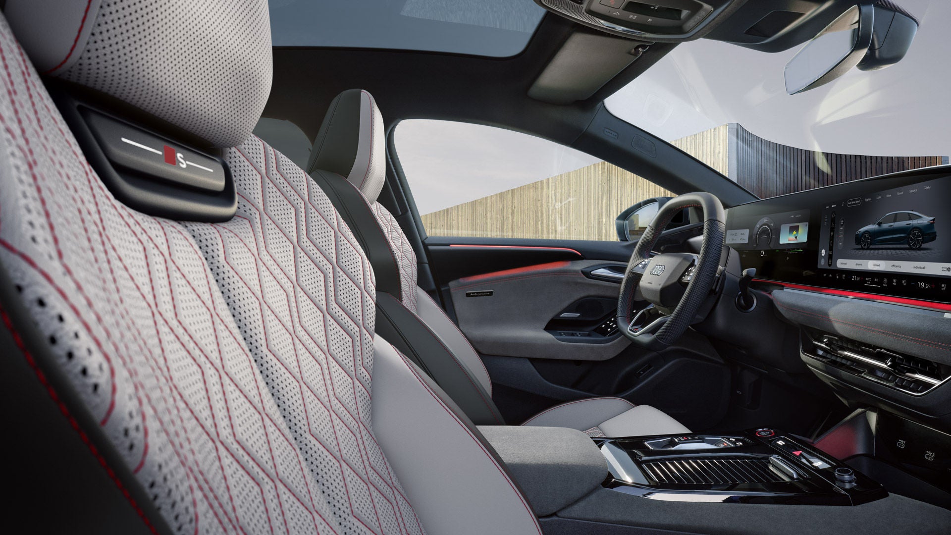 Blick von der Beifahrer-Seite in das Cockpit des S6 Sportback e-tron. Die Sitze haben Bezüge in Leder diamantsilver/jetgrau und Karmesinrote Kontrastnähte. Das Ambientelicht ist ebenfalls rot.